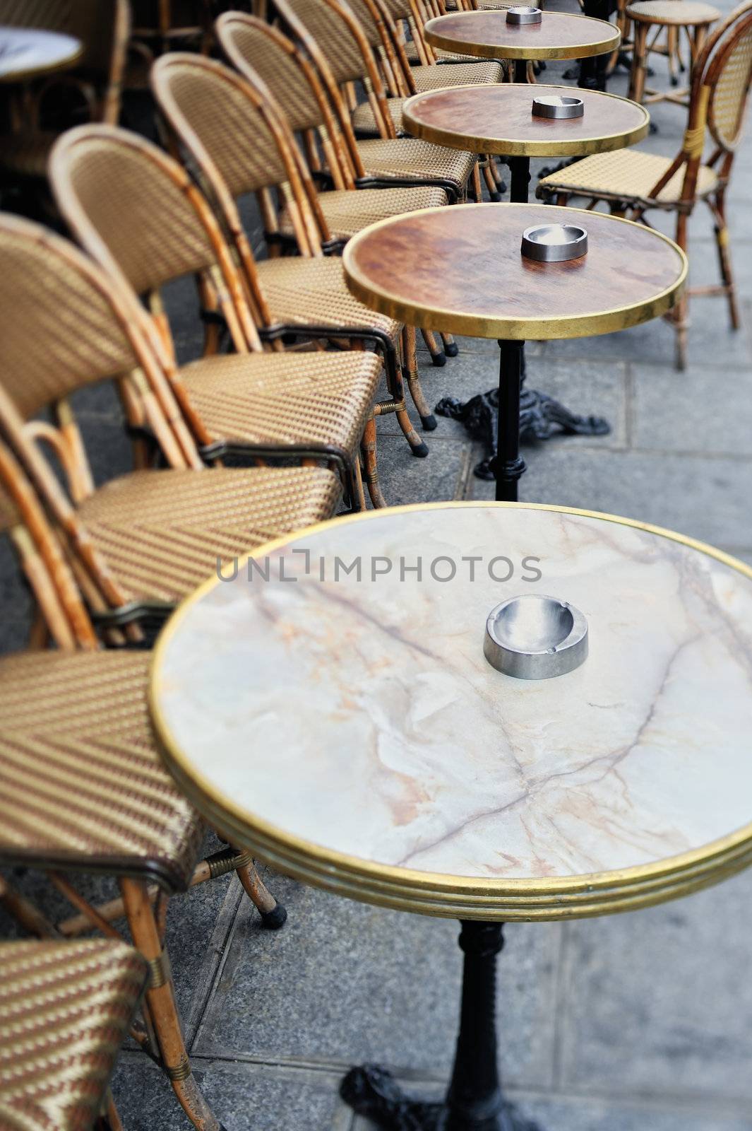 Round tables and chairs in cafe in Paris. Photo with tilt-shift effect