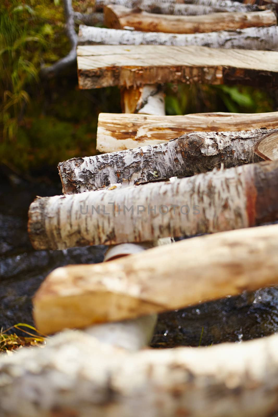 Wooden bridge over a stream close up