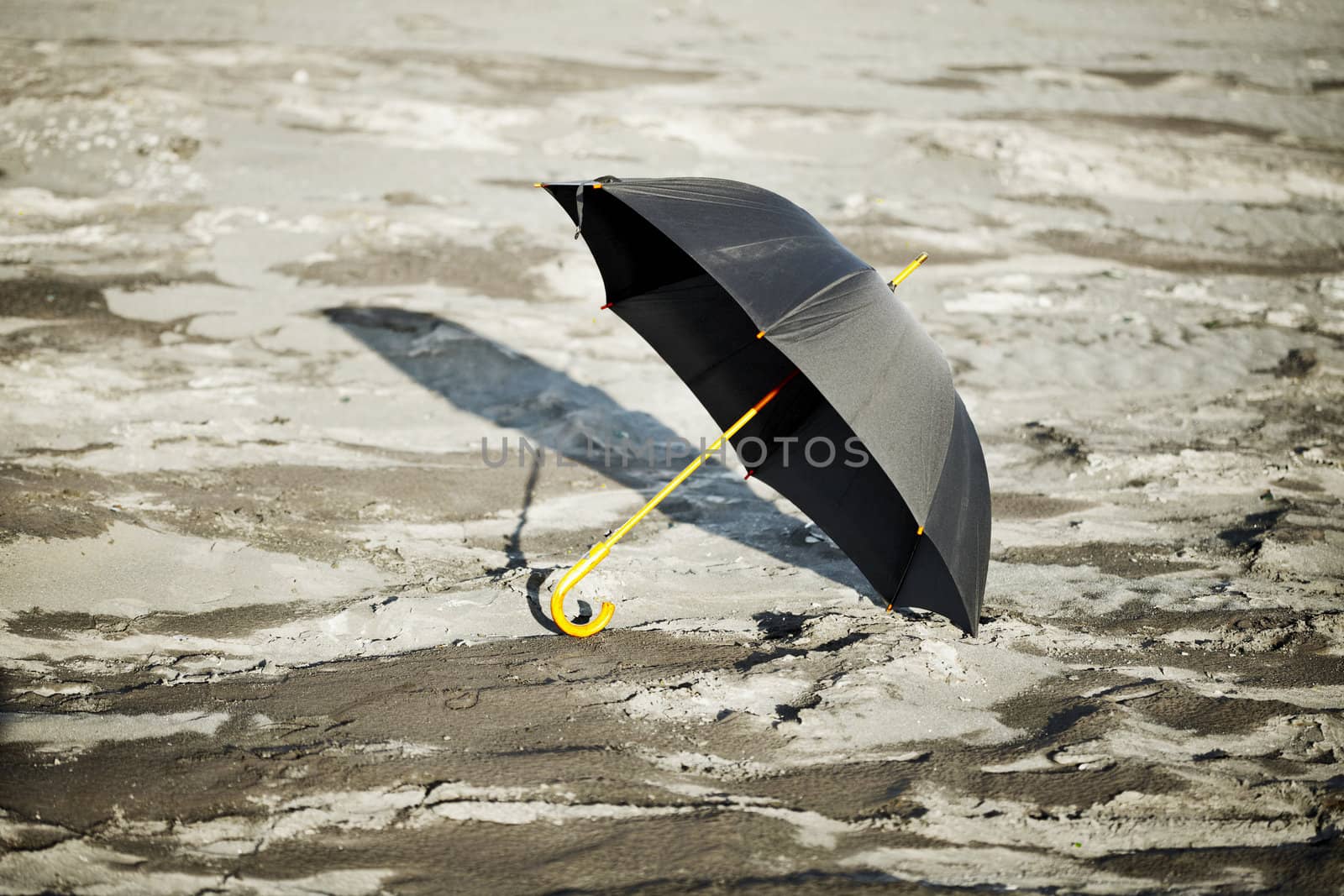 Large old-fashioned black umbrella in the desert