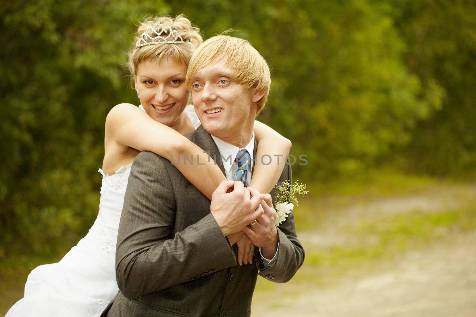Happy young bride and groom hugging outdoors