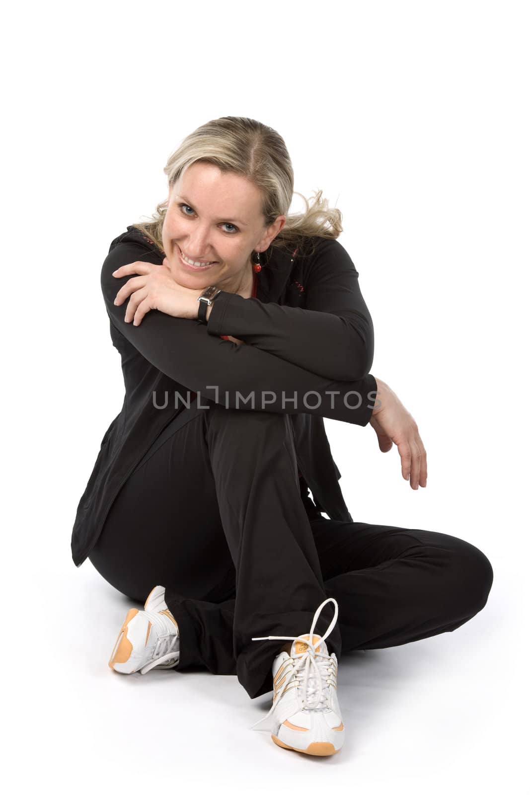 Young women with sportswear sitt on the floor. White background