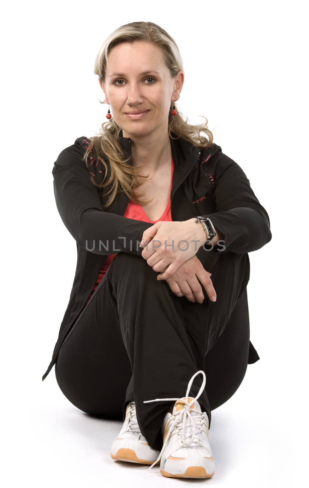 Young women with sportswear sitt on the floor. White background