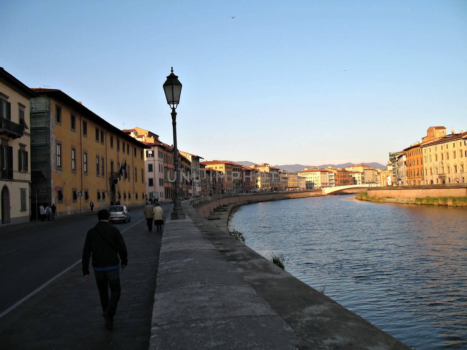 A view of the Arno River, buildings, bridge. Pisa, Italy
