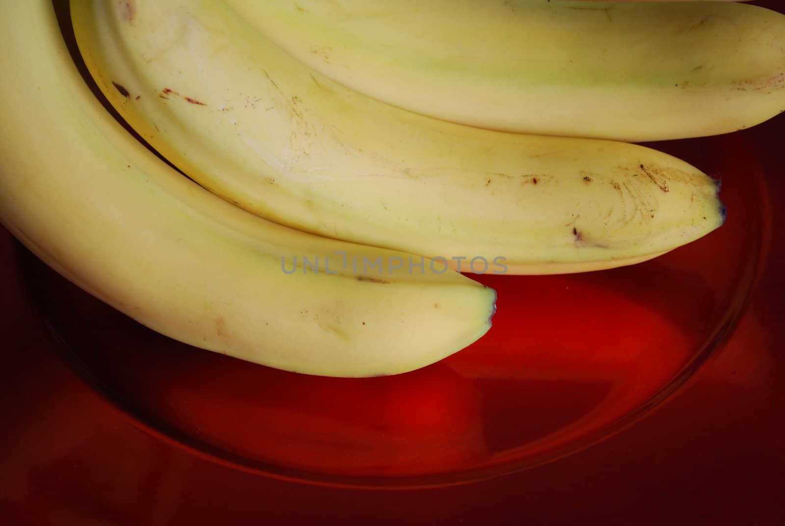 bunch of bananas on a red elegant plate