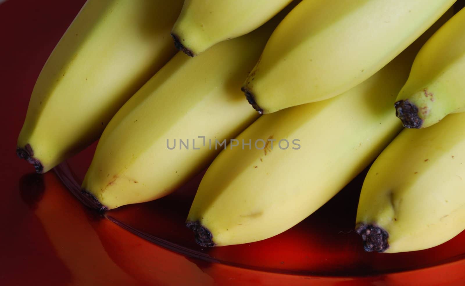 bunch of bananas on a red elegant plate