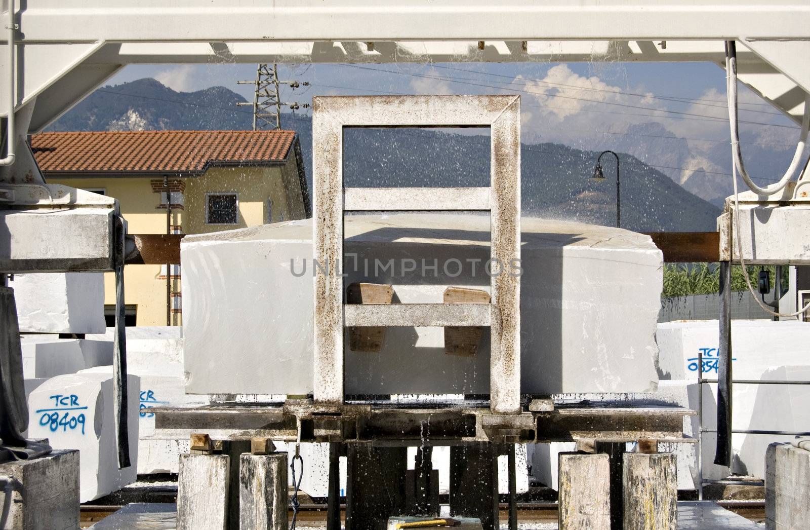 A cutting machine working a block of white marble, Tuscany, Italy