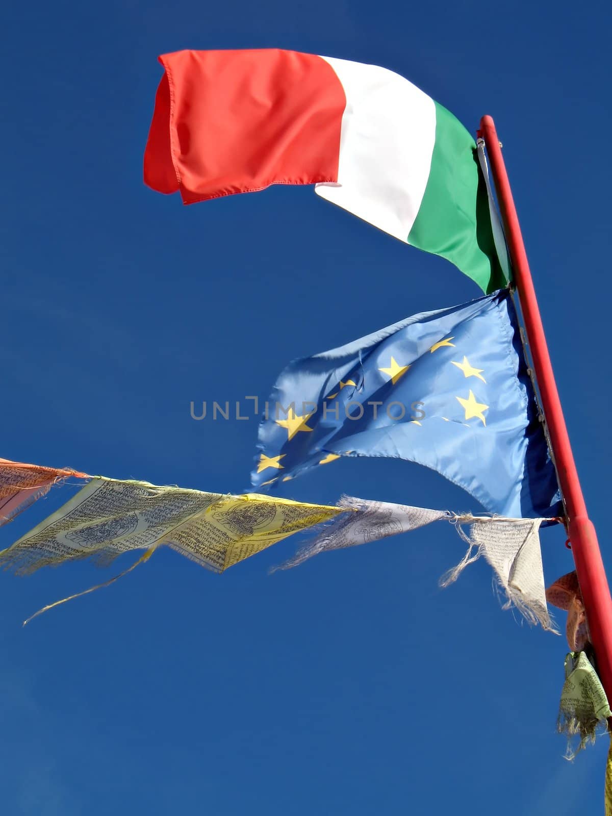 Italian flag, european union flag and prayer flag wave in the peace of high mountain refuge