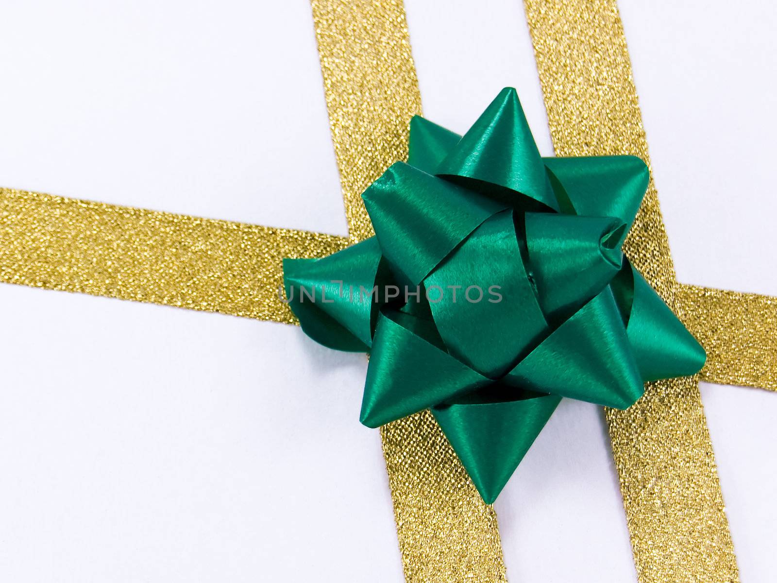 Christmas decoration golden ribbon with green bow isolated on white