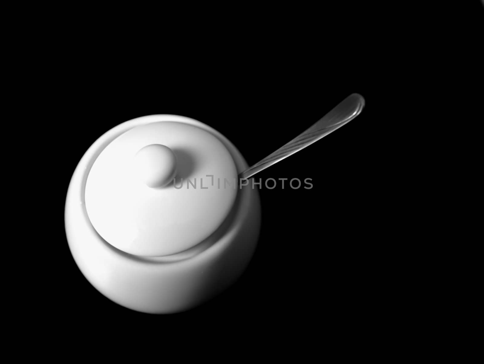 sugar bowl with a lid against black background