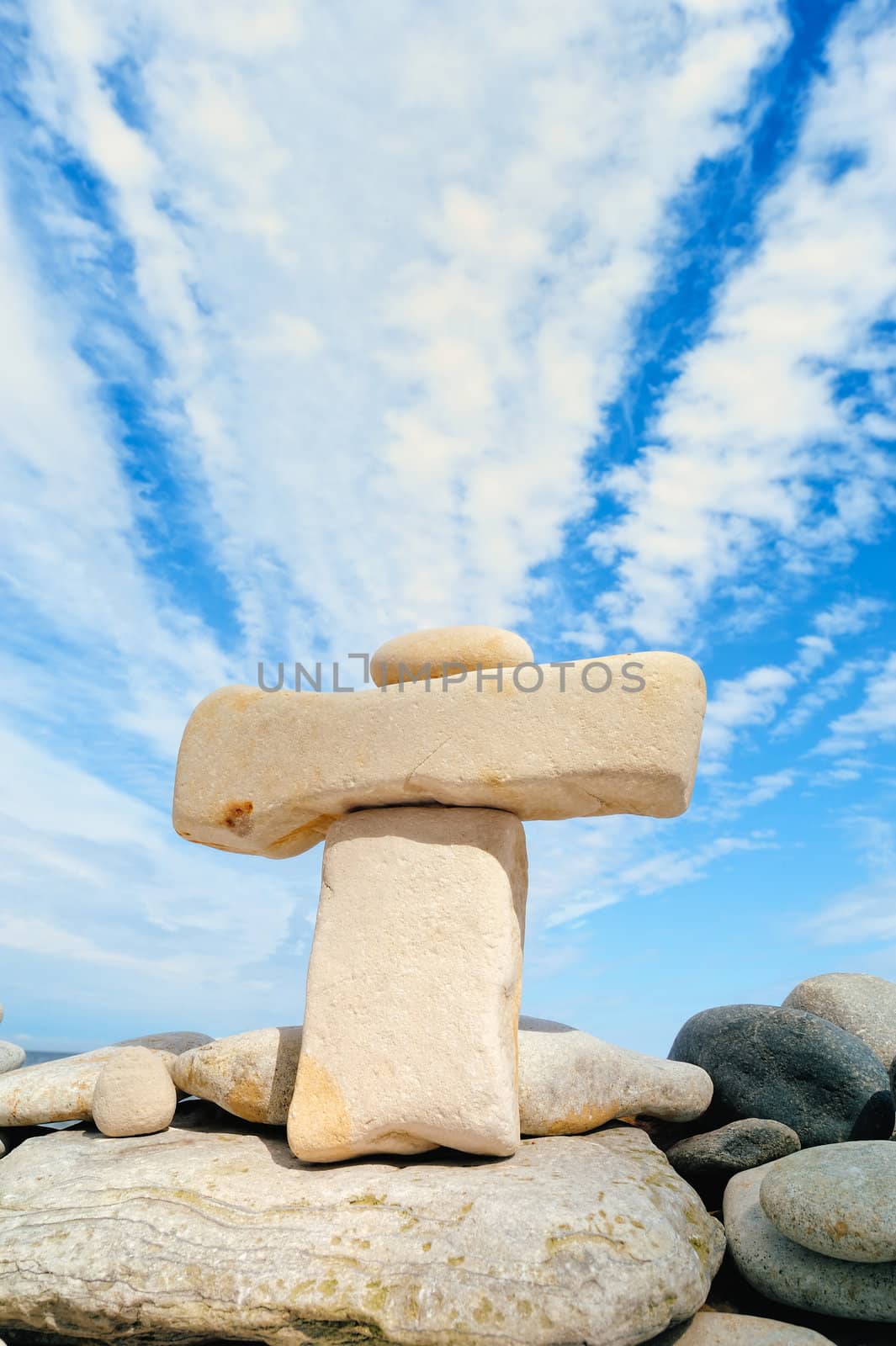 Small pebbles on the large horizontal stone on rocky coast