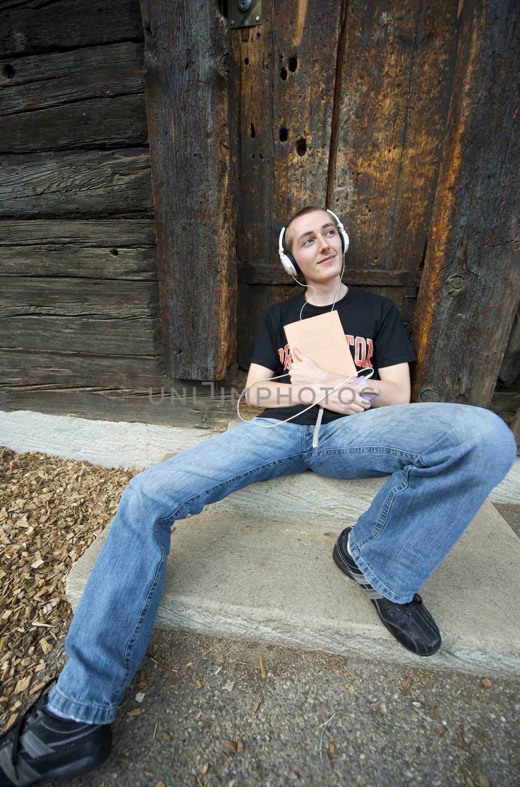 Man listening to the music in a park with white headphones