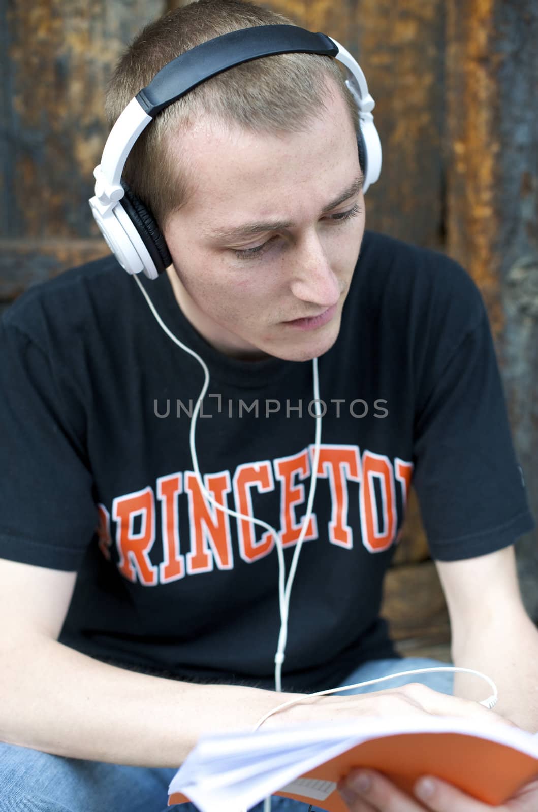 Man listening to the music in a park with white headphones