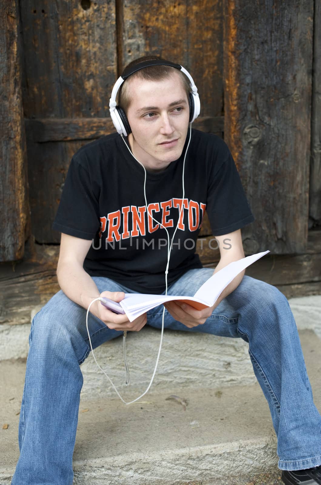 Man listening to the music in a park with white headphones