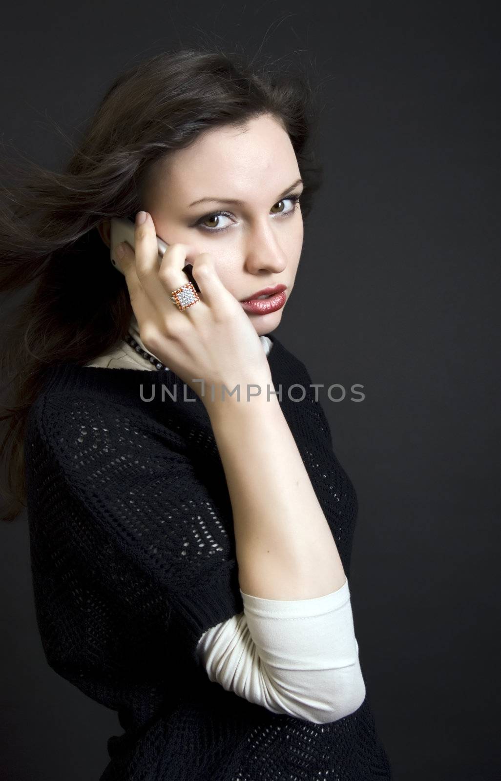 Portrait of a young beautiful brunette talking by the cell phone