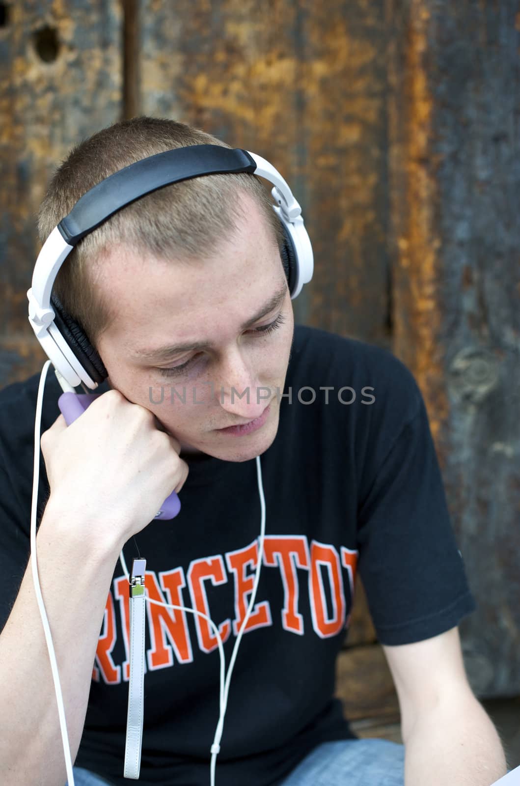 Man listening to the music in a park with white headphones