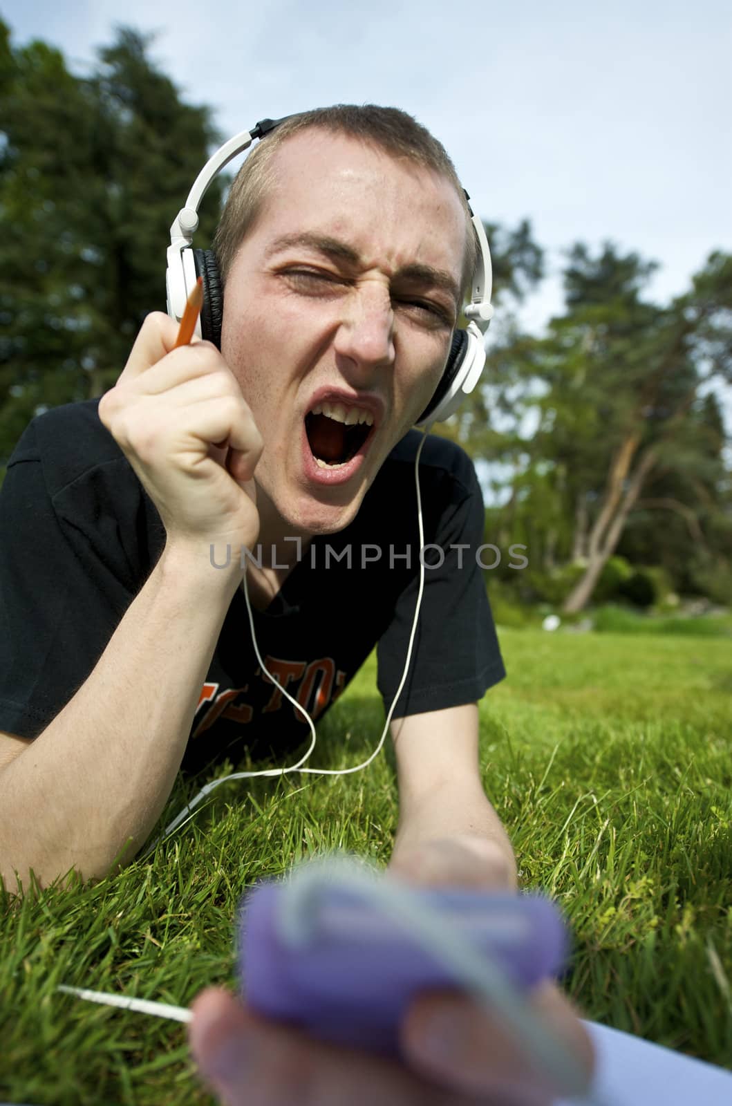 Man listening to the music in a park with white headphones