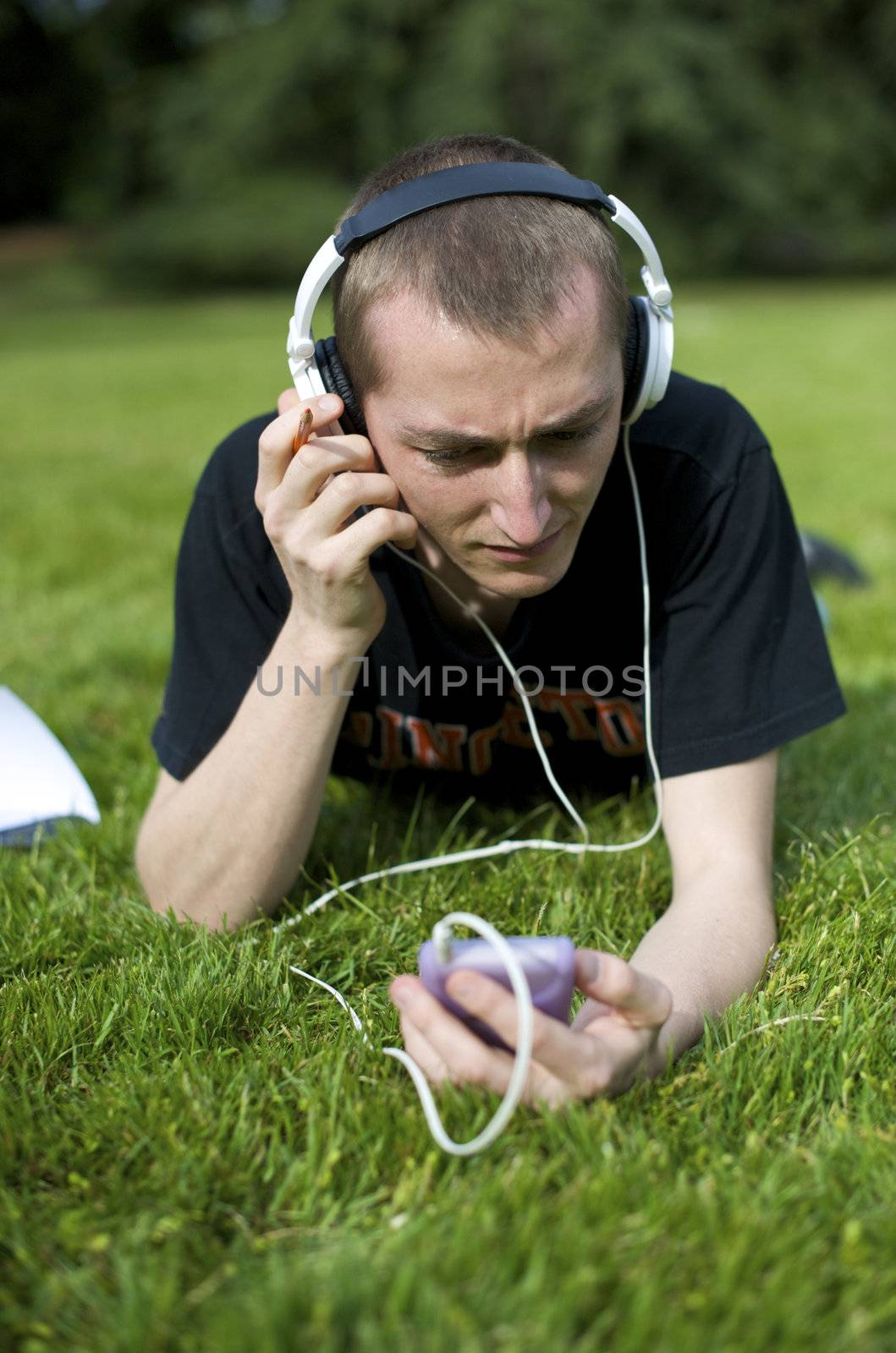 Man listening to the music in a park with white headphones