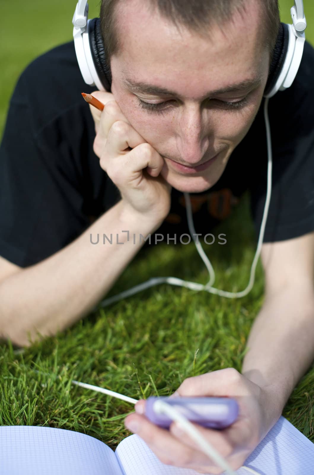 Man listening to the music in a park with white headphones