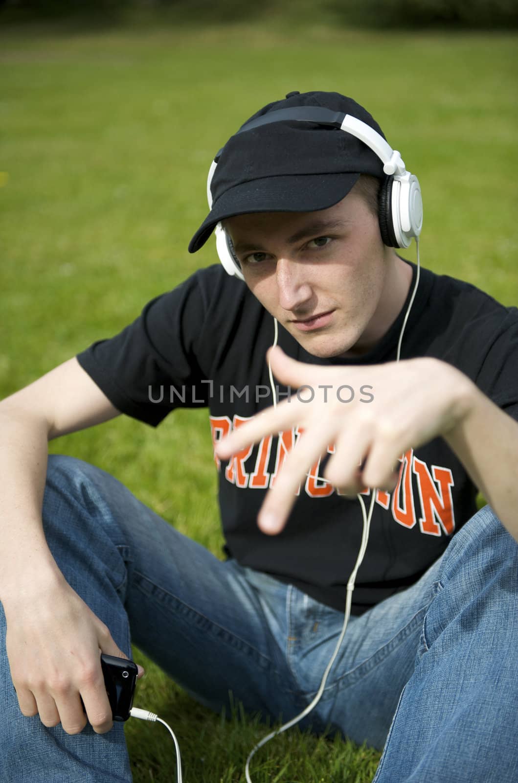 Man listening to the music in a park with white headphones