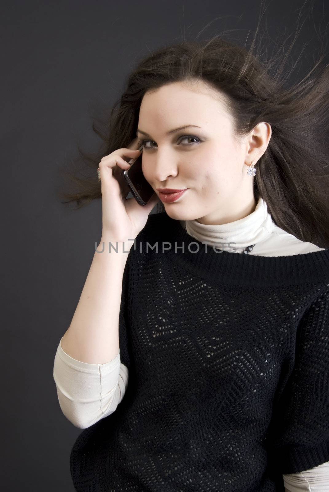 Portrait of a young beautiful brunette talking by the cell phone
