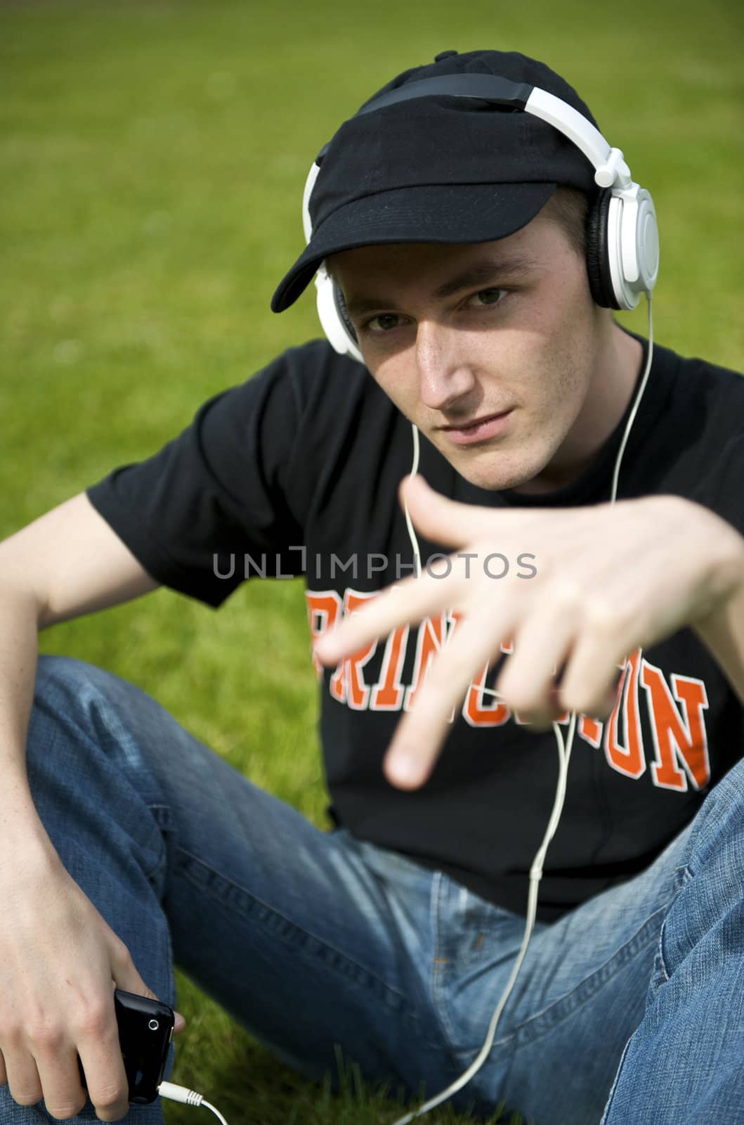 Man listening to the music in a park with white headphones