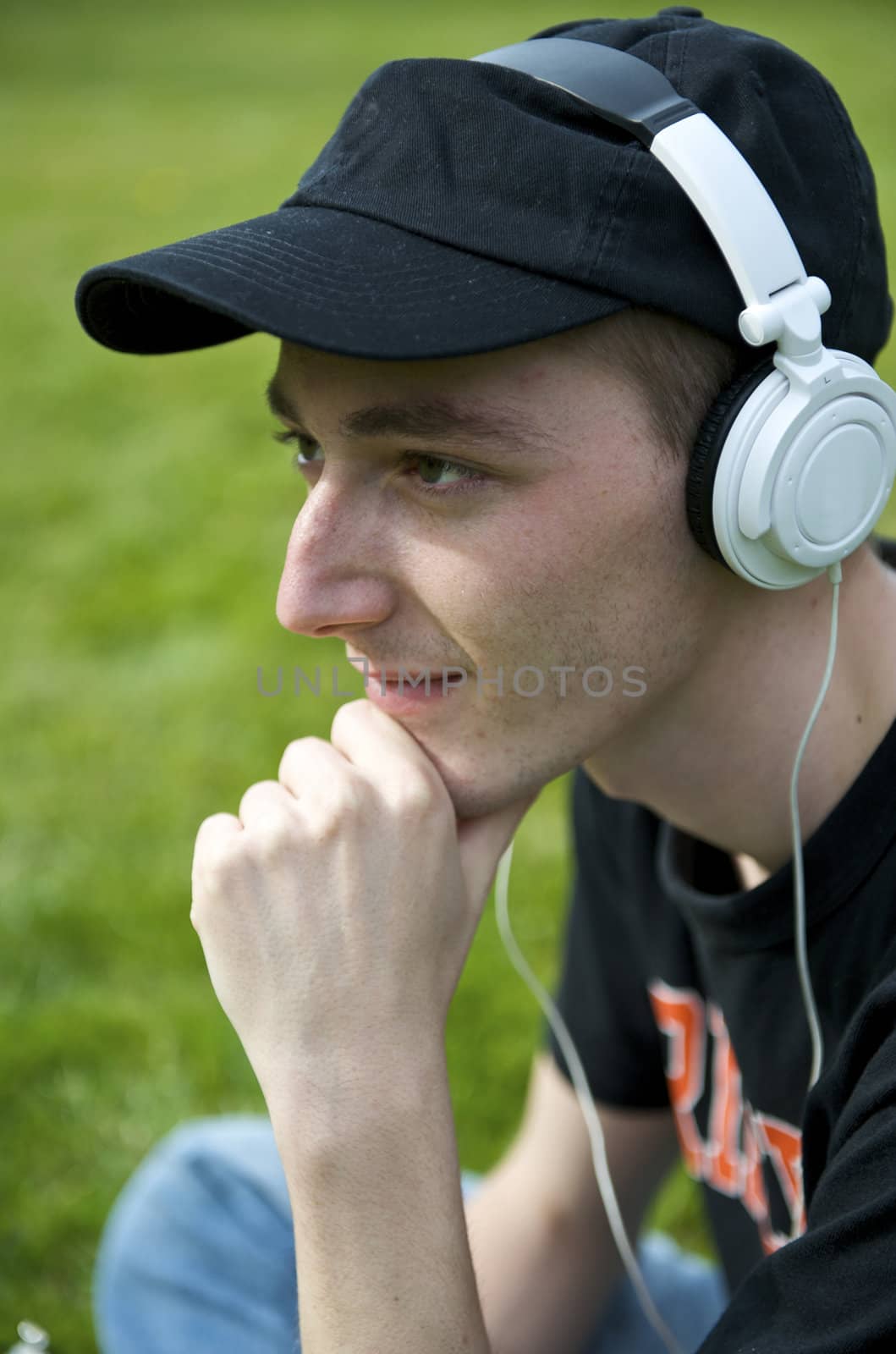 Man listening to the music in a park with white headphones