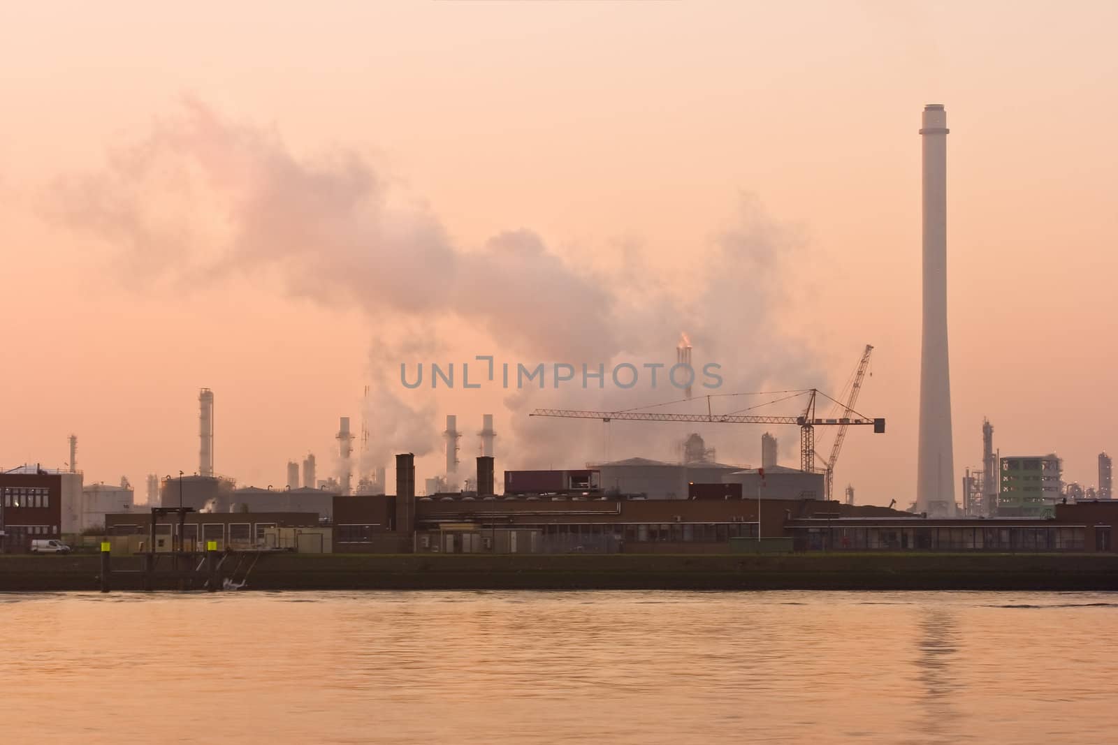 Misty riverside on early morning with industrial pollution by Colette