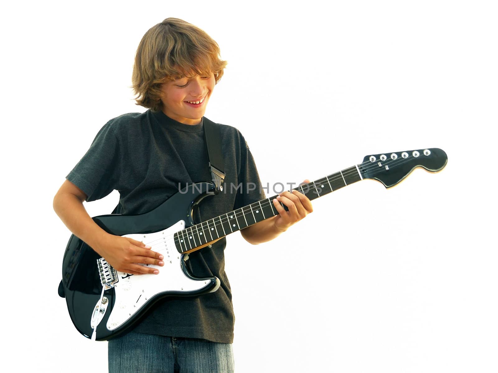 Smiling teen boy playing electric guitar isolated over white.