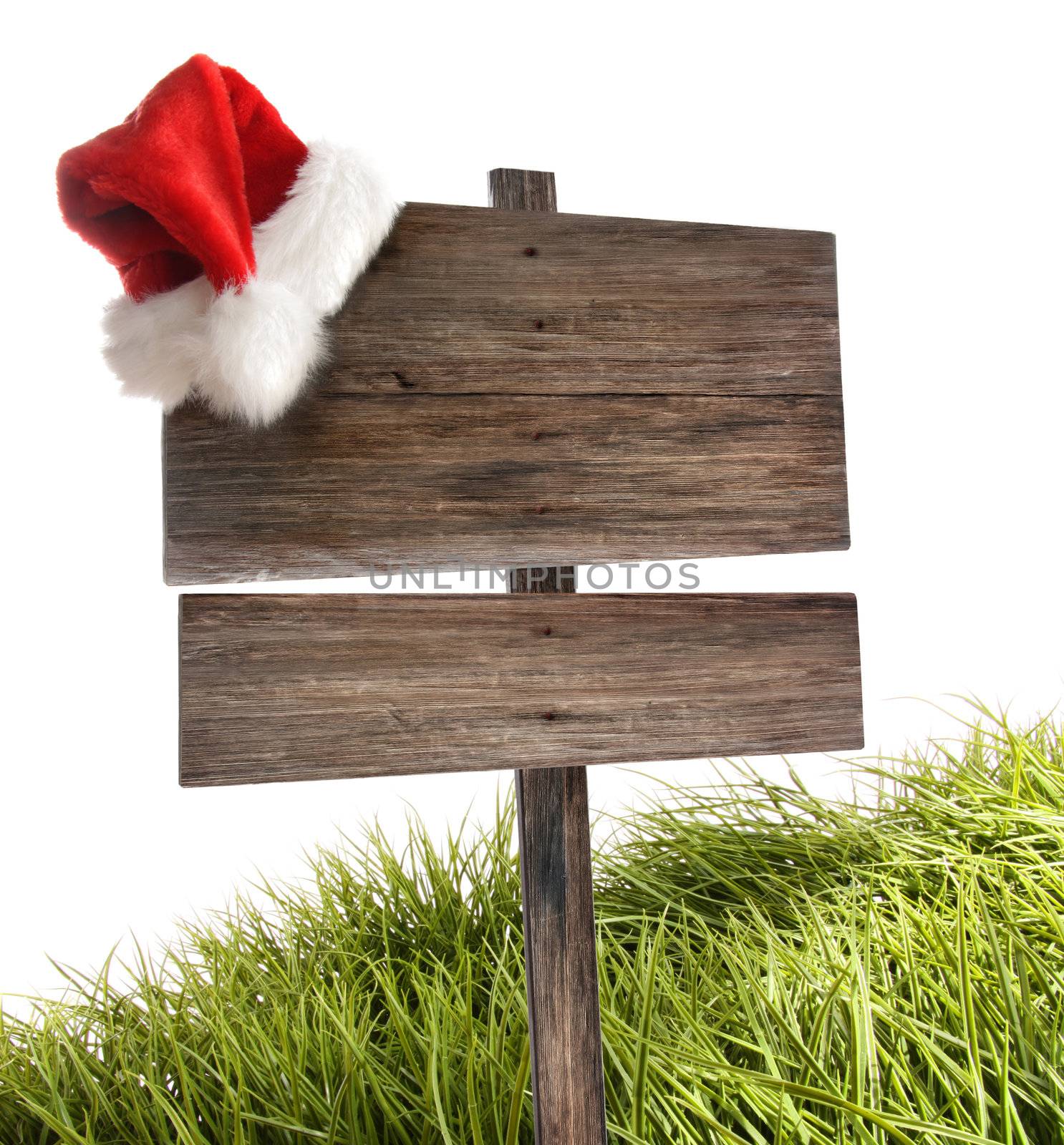 Weathered wooden sign with santa hat and grass on white