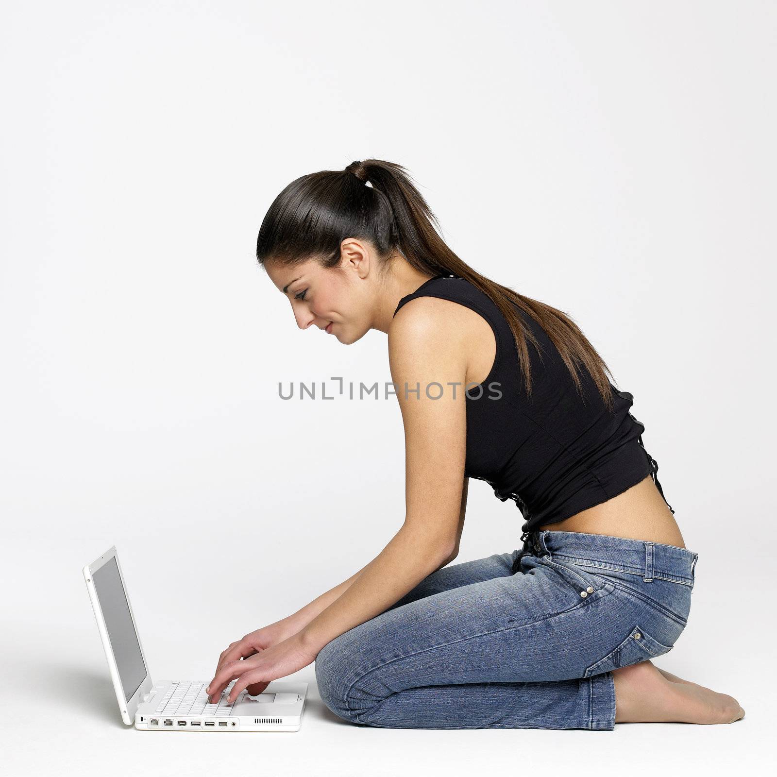 Pretty young girl sitting on floor with laptop