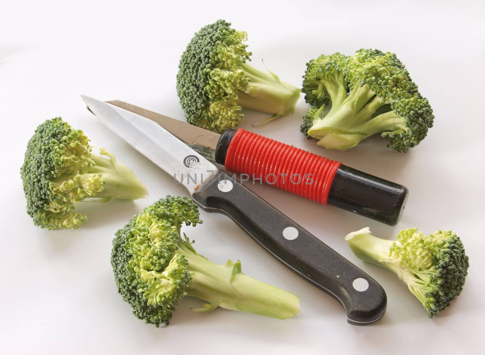 Fresh broccoli with a vegetable knife and peeler.