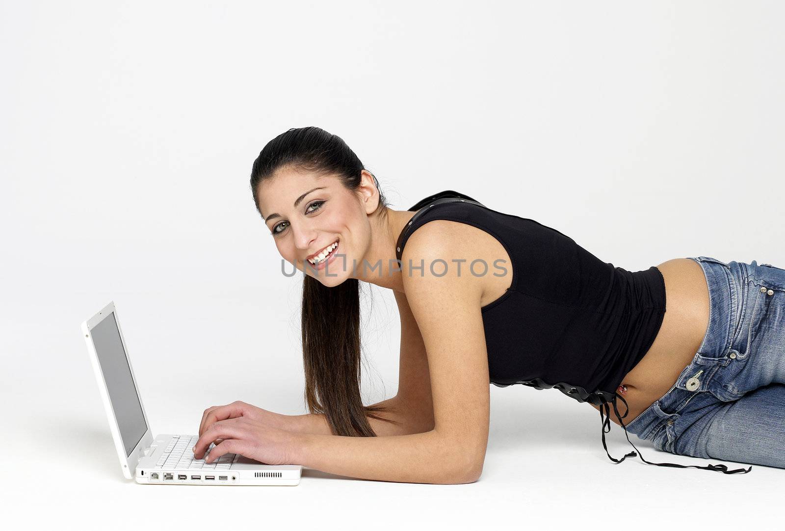 Pretty young girl lying on floor with laptop