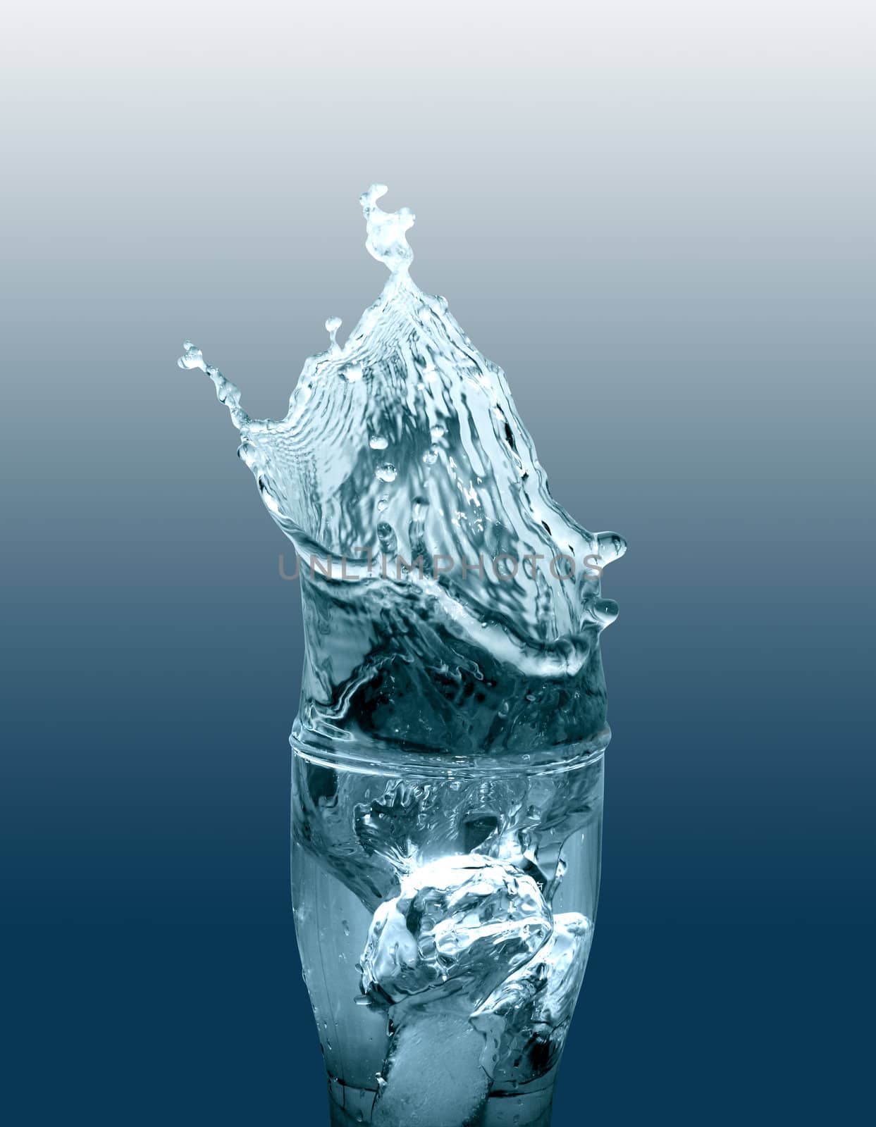 Glass of splashing water isolated on gradient background with clipping path