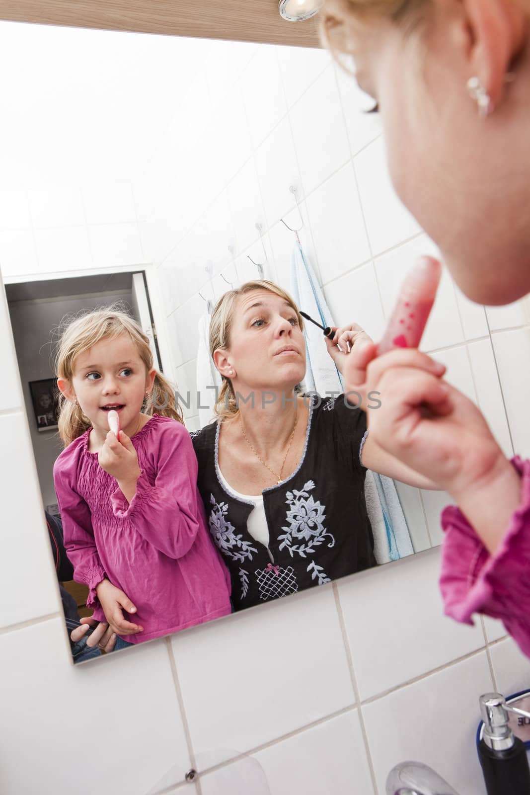 Mother and daughter put on make-up by gemenacom