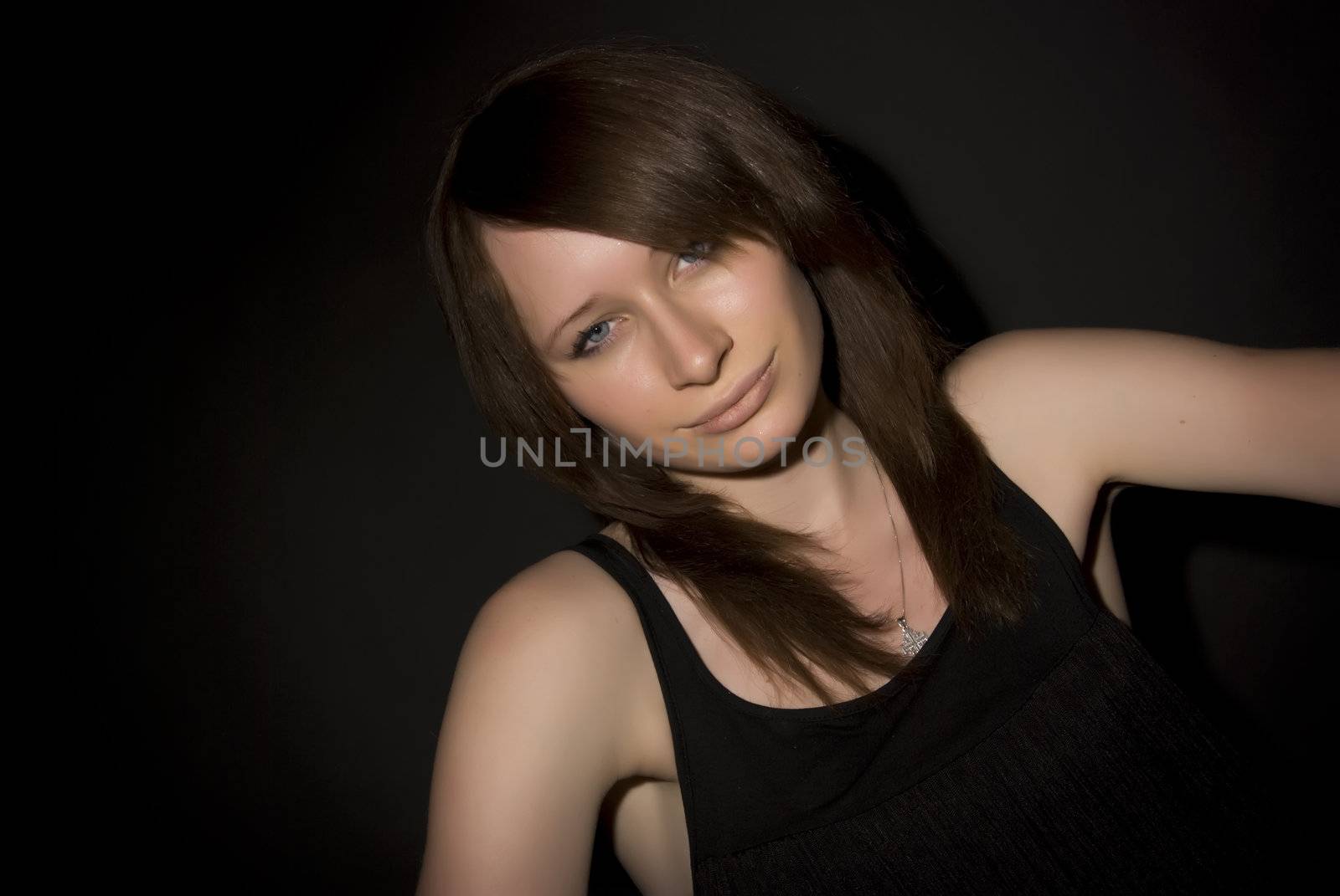 Portrait of a young beautiful brunette over black background