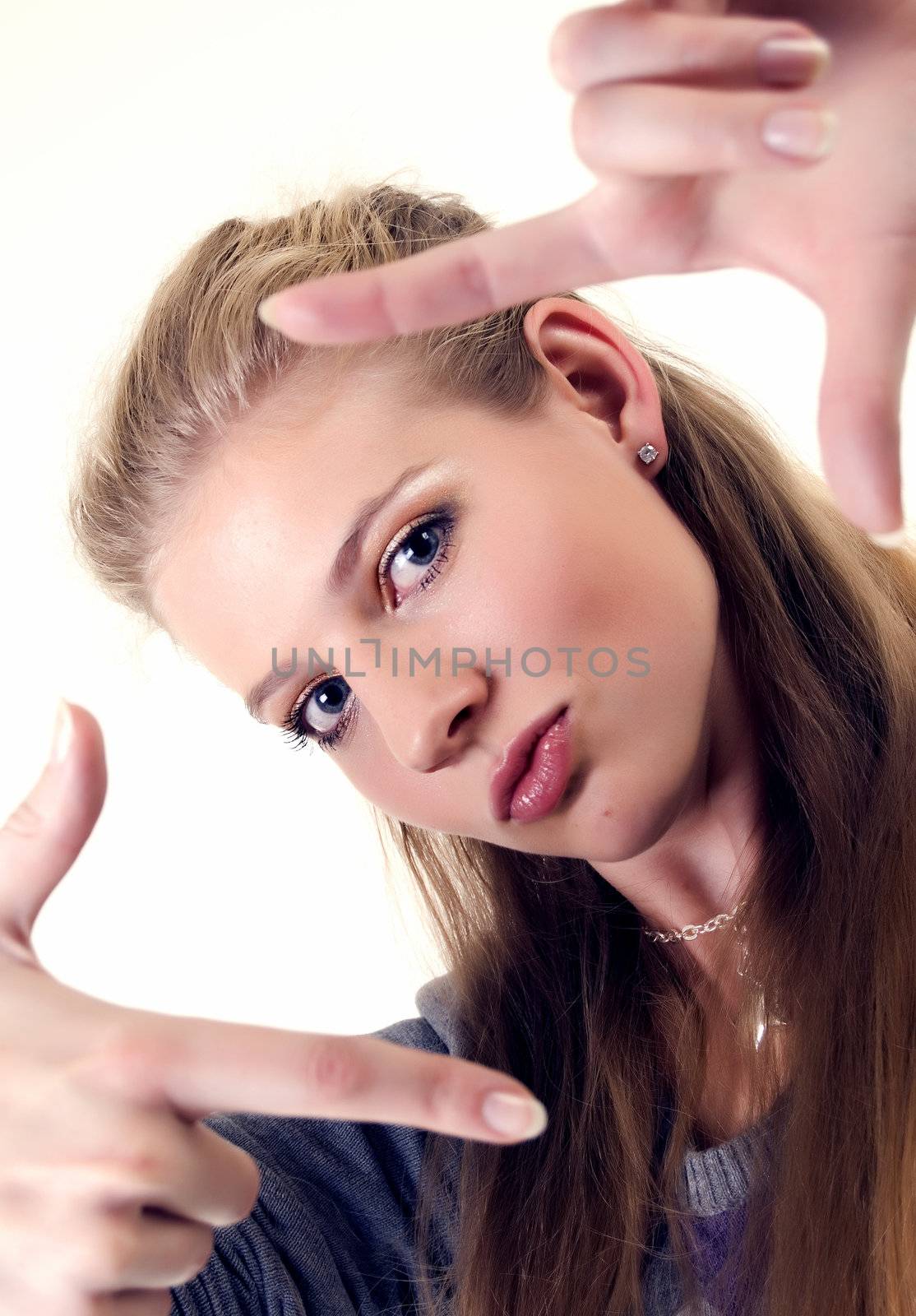 Portrait of a young beautiful girl showing framing hand gesture