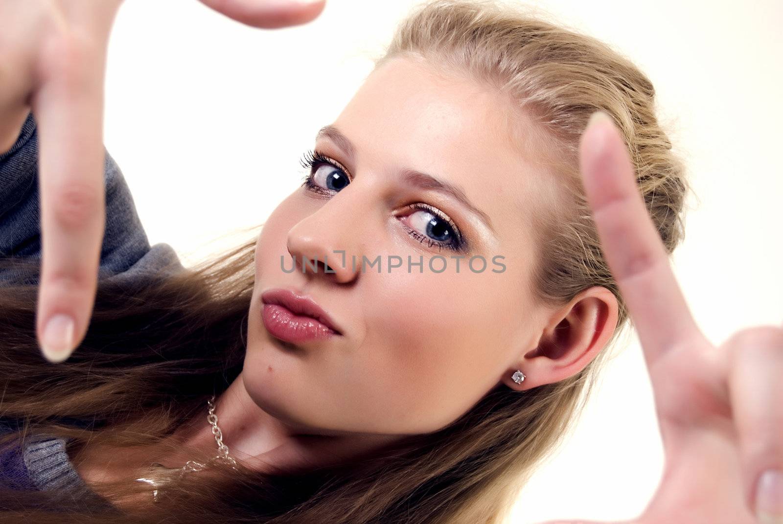 Portrait of a young beautiful girl showing framing hand gesture