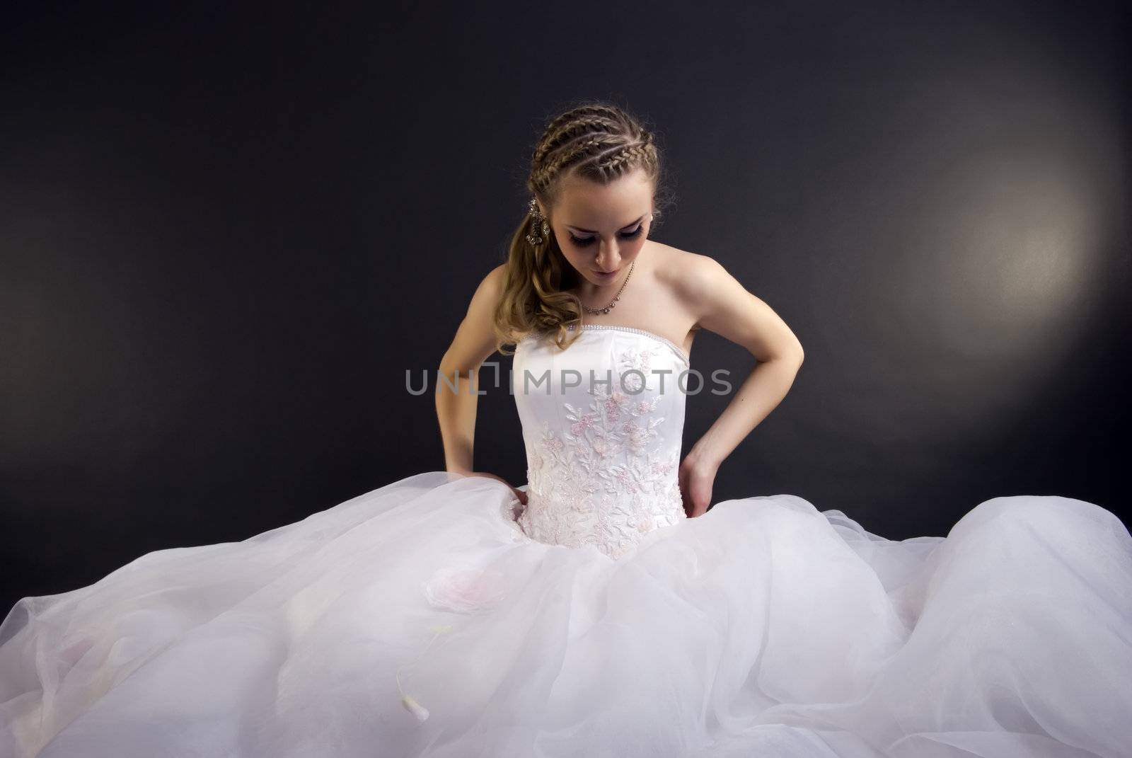 Young beautiful bride in wedding dress over black 