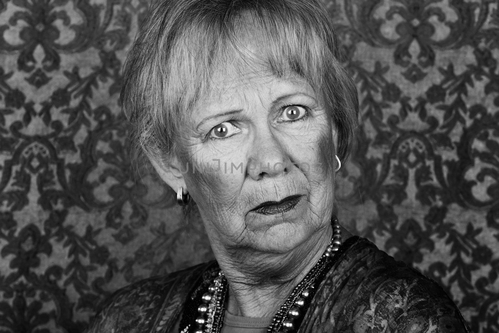 Portrait of skeptical senior woman in front of gold background