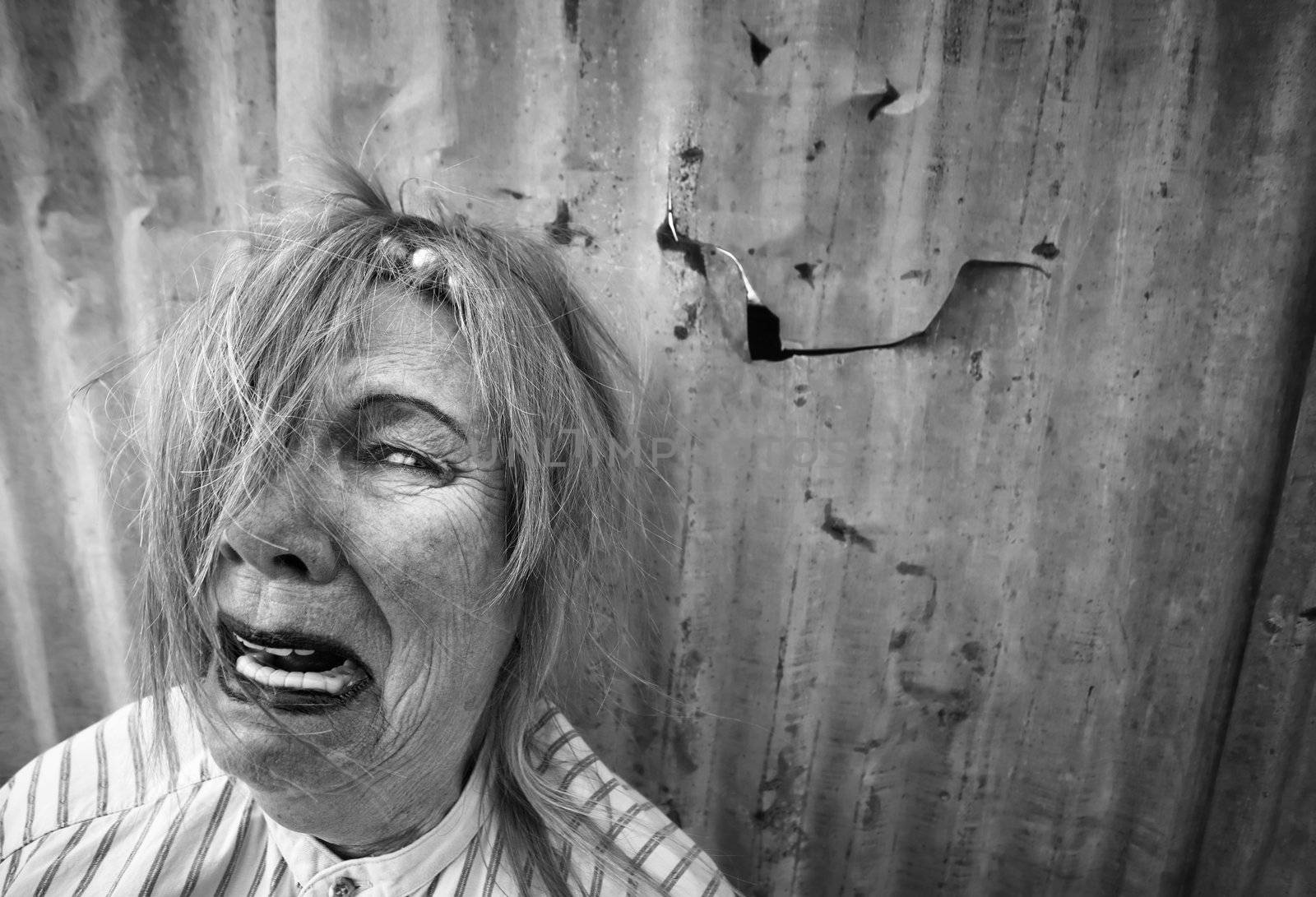 Senior homeless woman with too much makeup crying