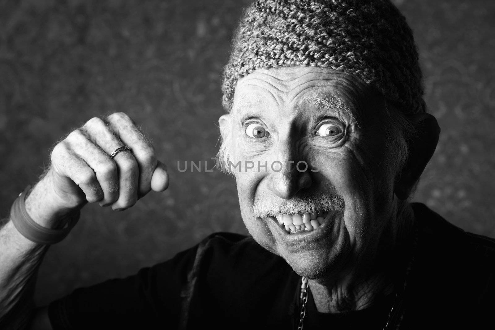 Senior man in knit cap making a fist