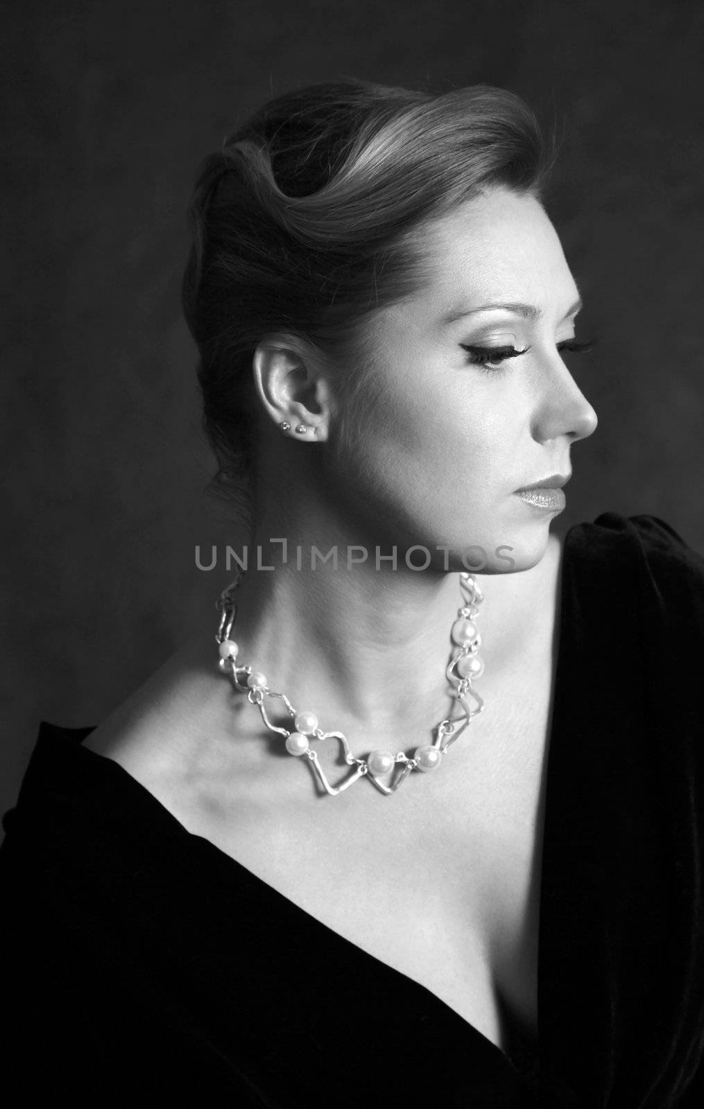 Portrait of the beautiful woman in a pearl necklace in studio