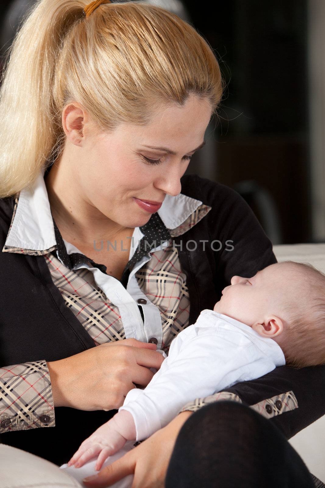 Attractive young mother with her newborn son in her arms