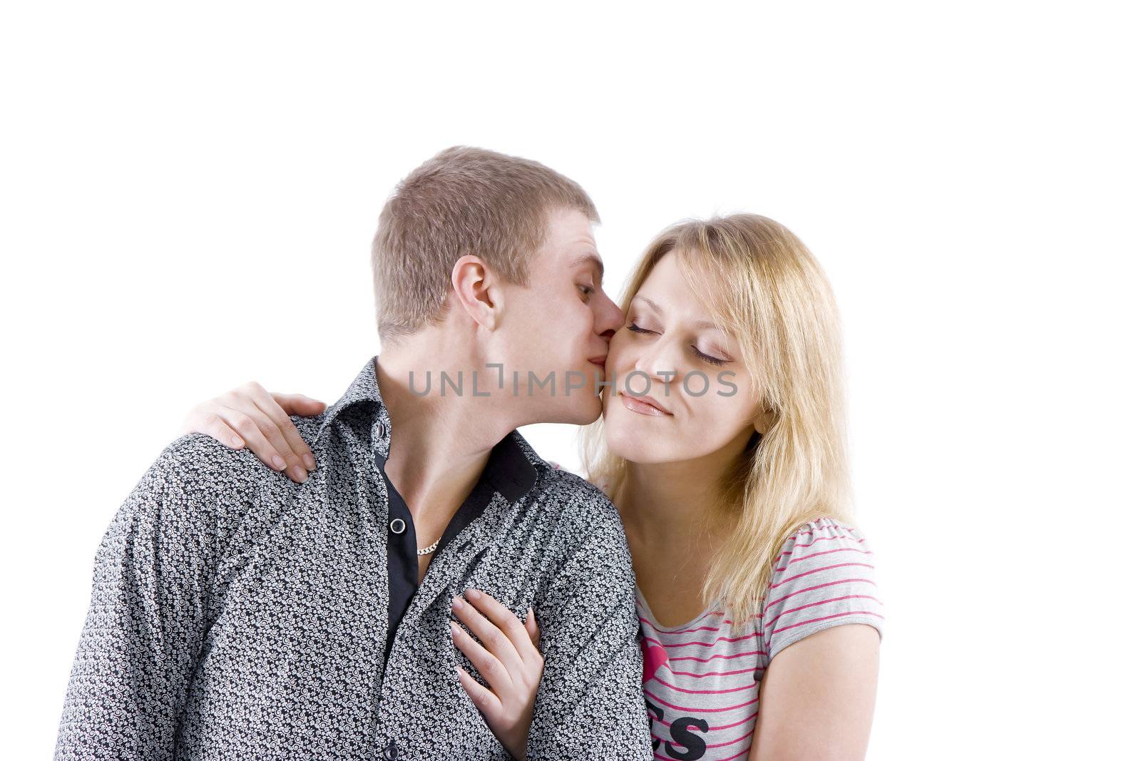 happy young couple. Boy kisses girl on the cheek
