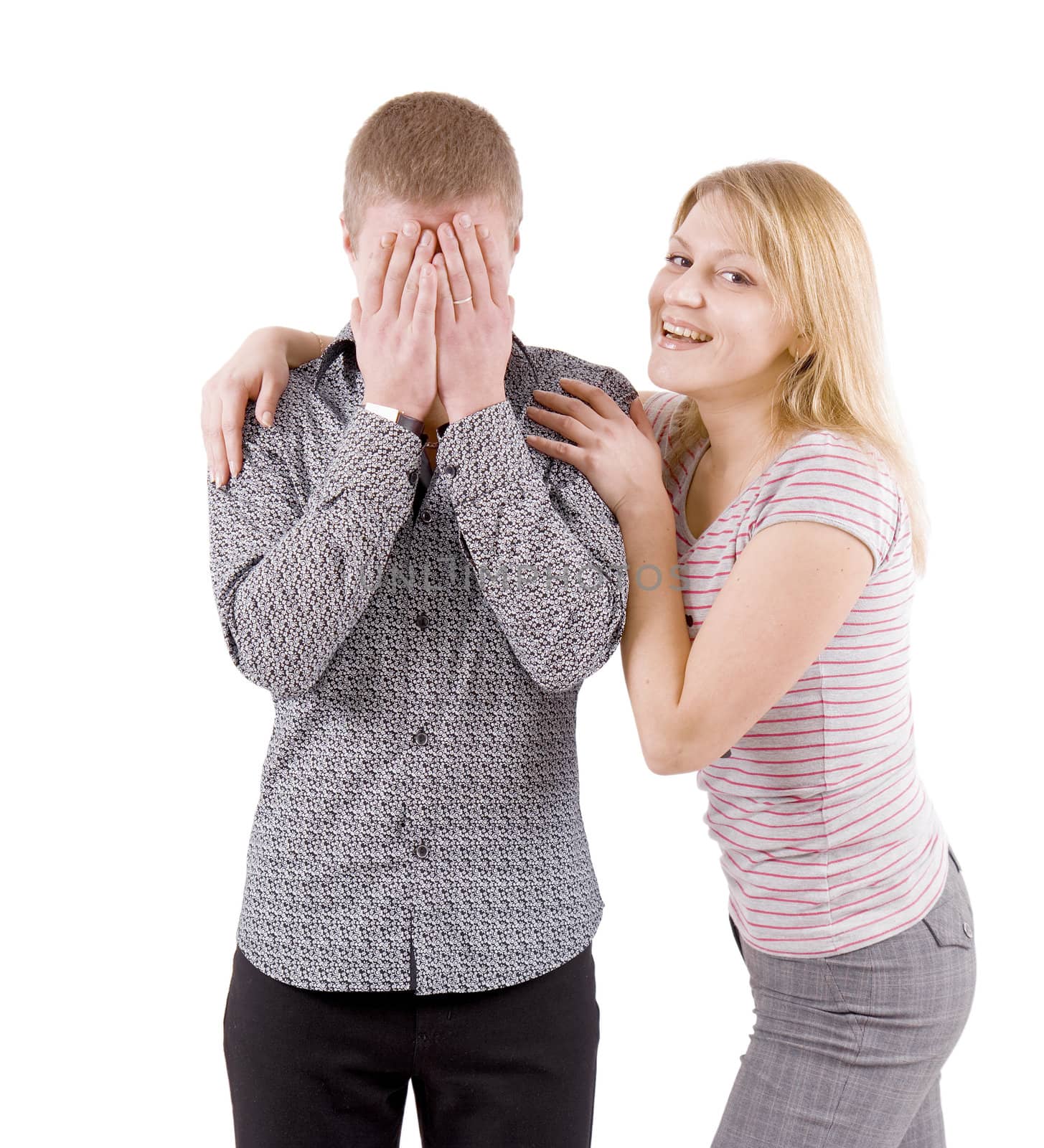 young couple. A man hides his face. The woman smiles hugging a man