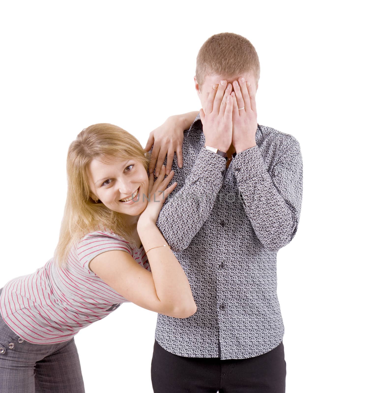 young couple. A man hides his face. The woman smiles hugging a man
