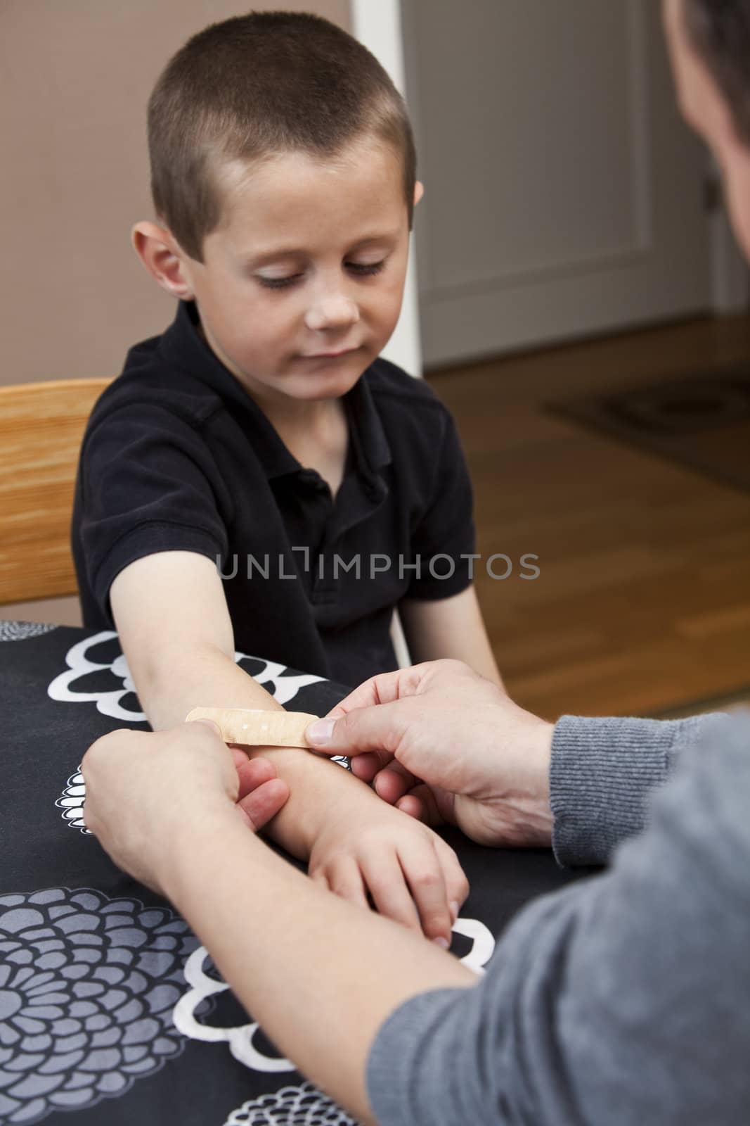 Man puting Band-Aid on sons arm