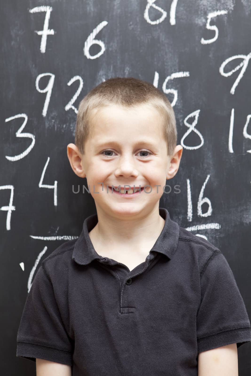 Young Boy in front of the blackboard at school