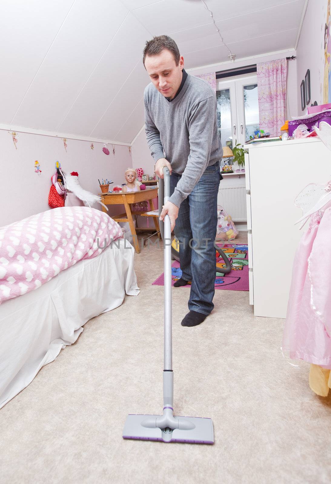Man with a vacuum cleaner in a girls room