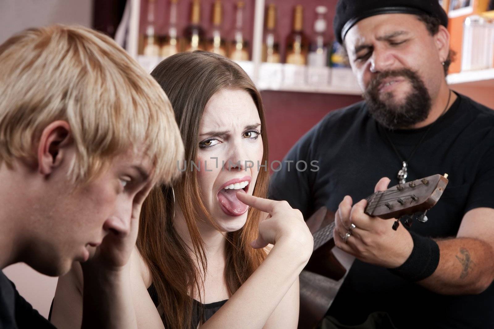 Couple in coffee house listening to a bad guitarist